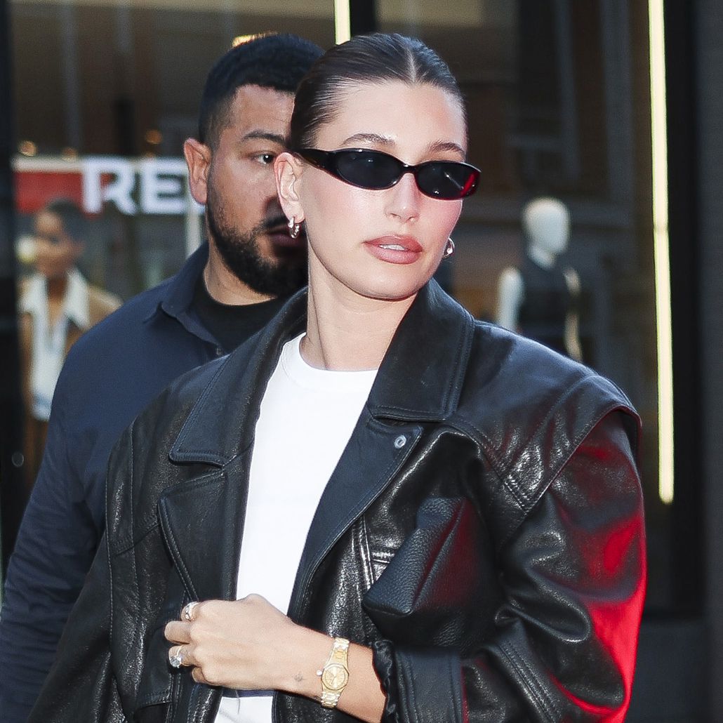  Hailey Bieber wearing a leather bomber jacket, white T-shirt, and athletic shorts in NYC