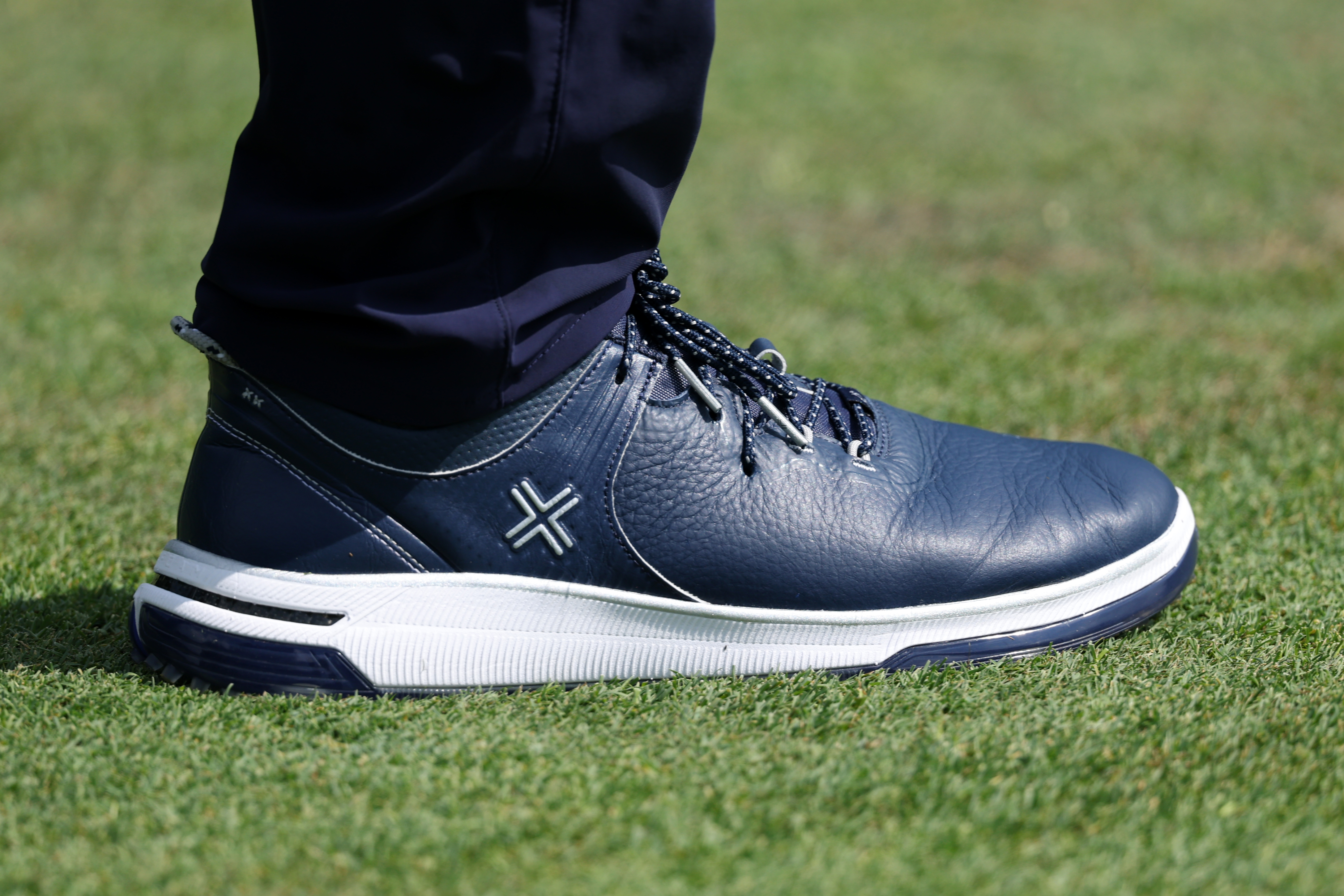 A close-up of Justin Rose's PAYNTR golf shoes