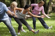 Older adults take a tai chi class in the park.