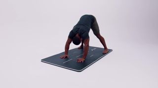 A Pliability athlete demonstrating the wide stance down dog pose