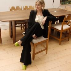 woman in black suit and green Prada shoes