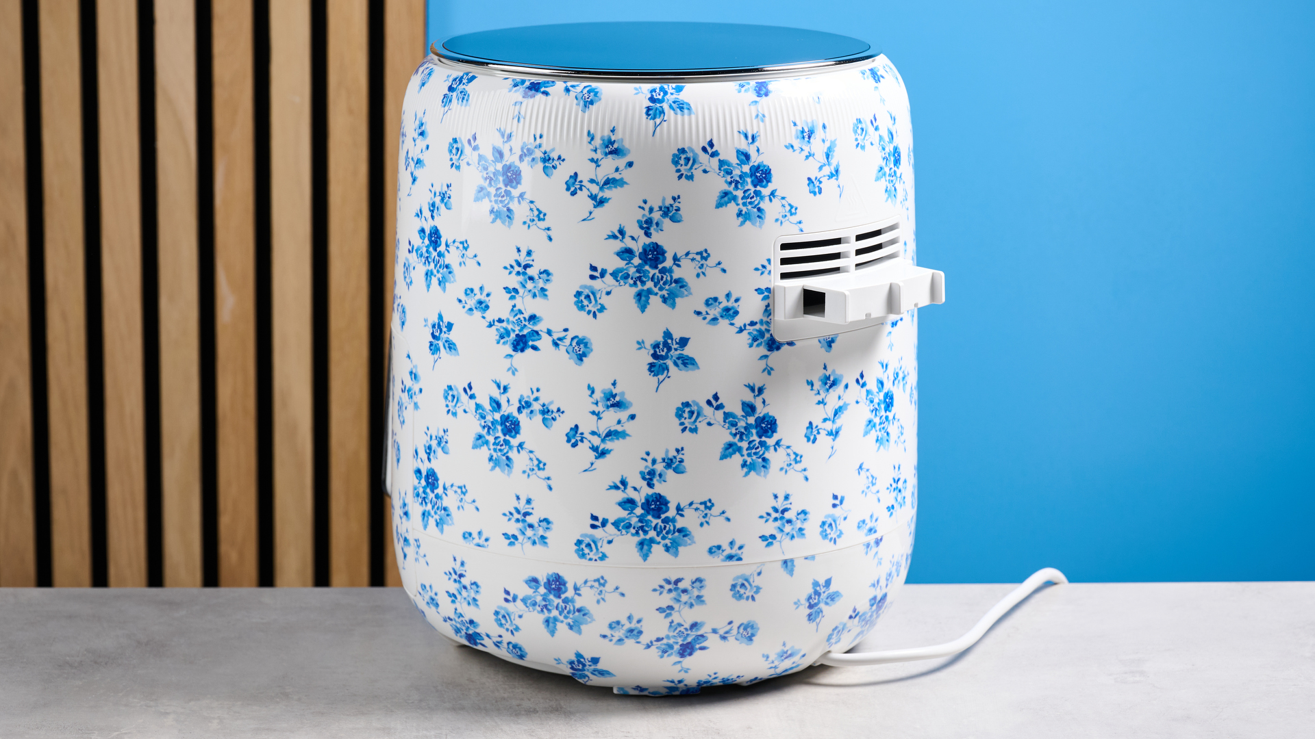 the Laura Ashley Air Fryer in blue and white floral print, showing the air fryer basket and black touchscreen on the top