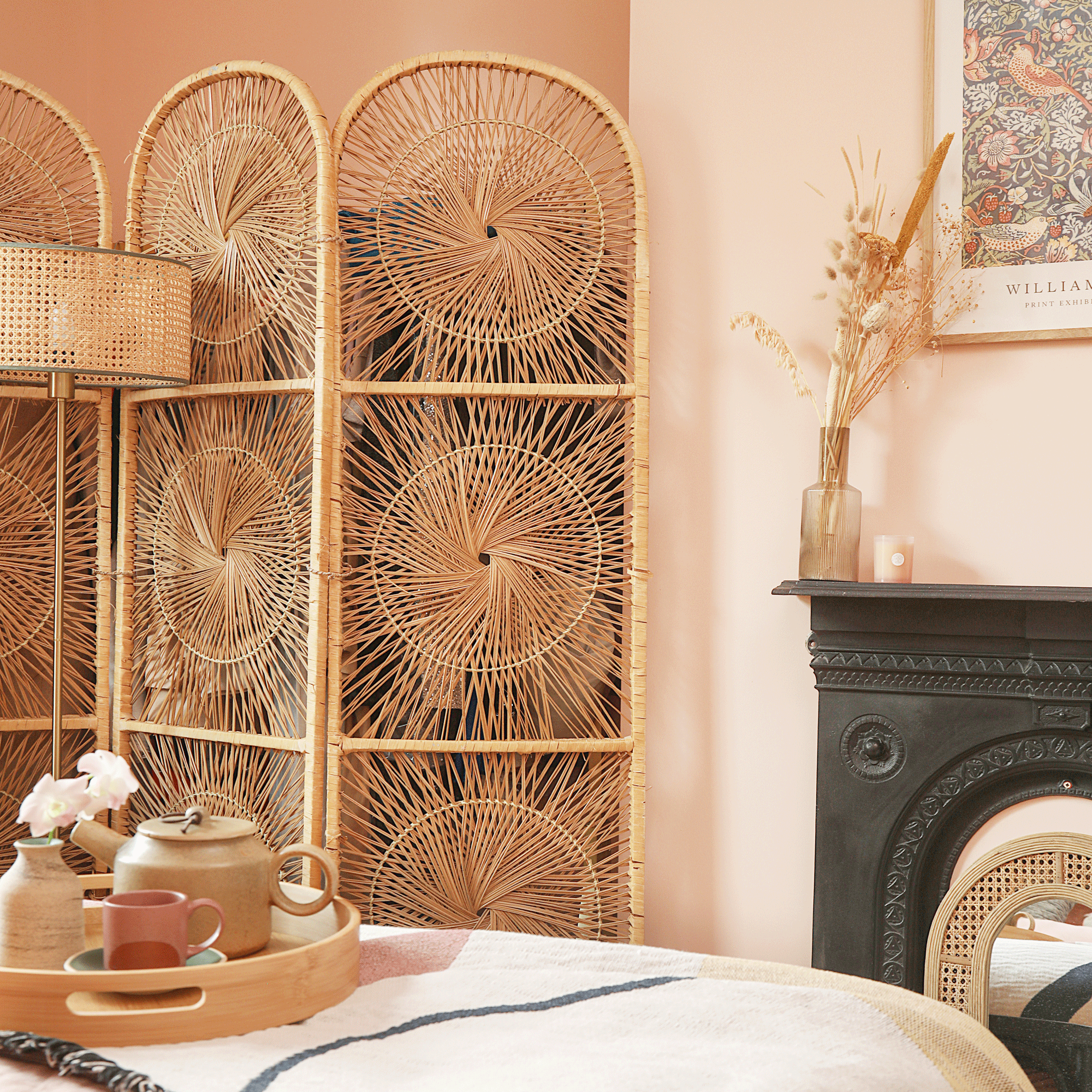 a peachy pink coloured bedroom with a retro wicker woven screen