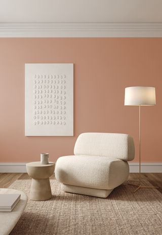 Beige-pink living room with neutral rugs and a fluffy white accent chair