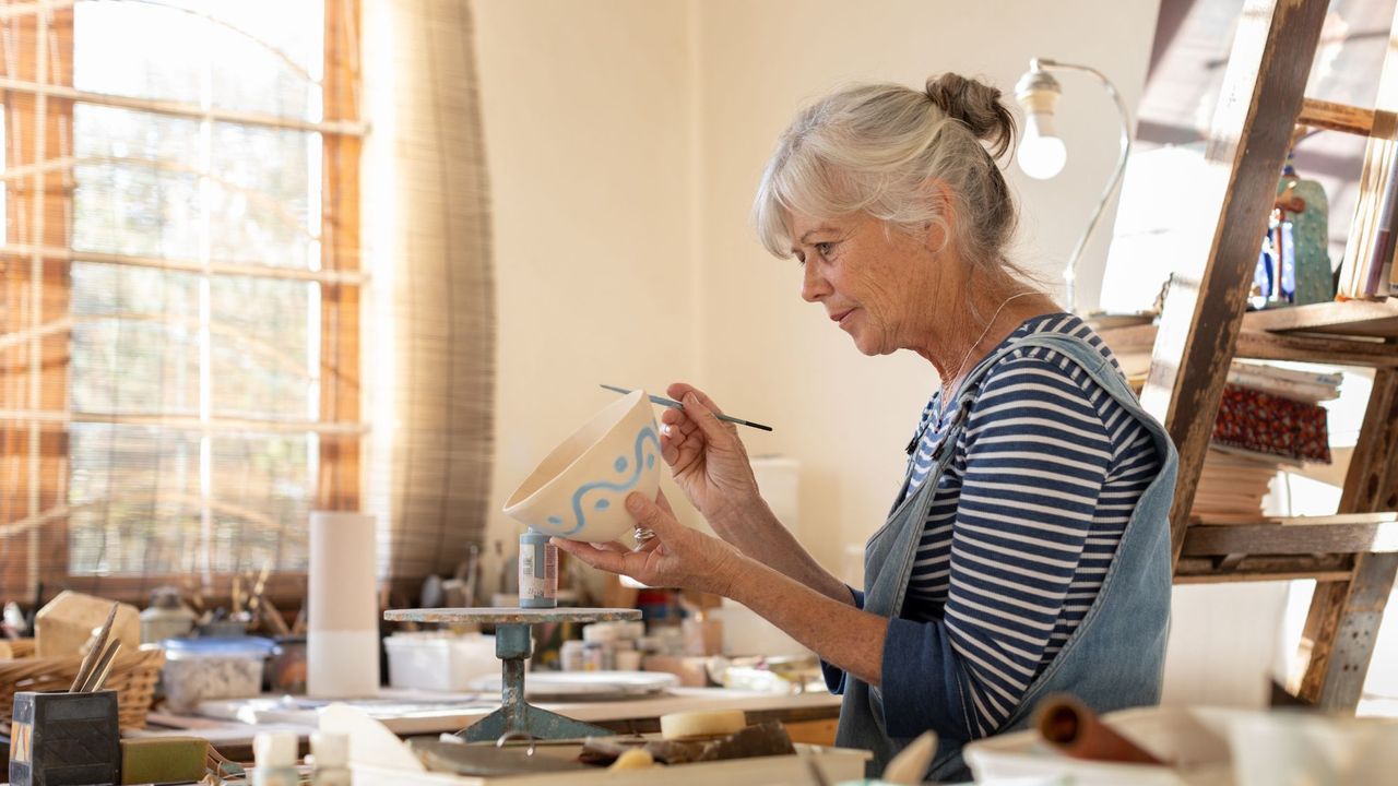 Side hustle: woman painting pottery