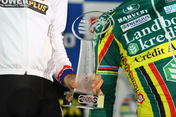 Niels Albert and Sven Nys hold the World Cup trophy.