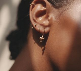 Woman with several gold piercings in her ear.