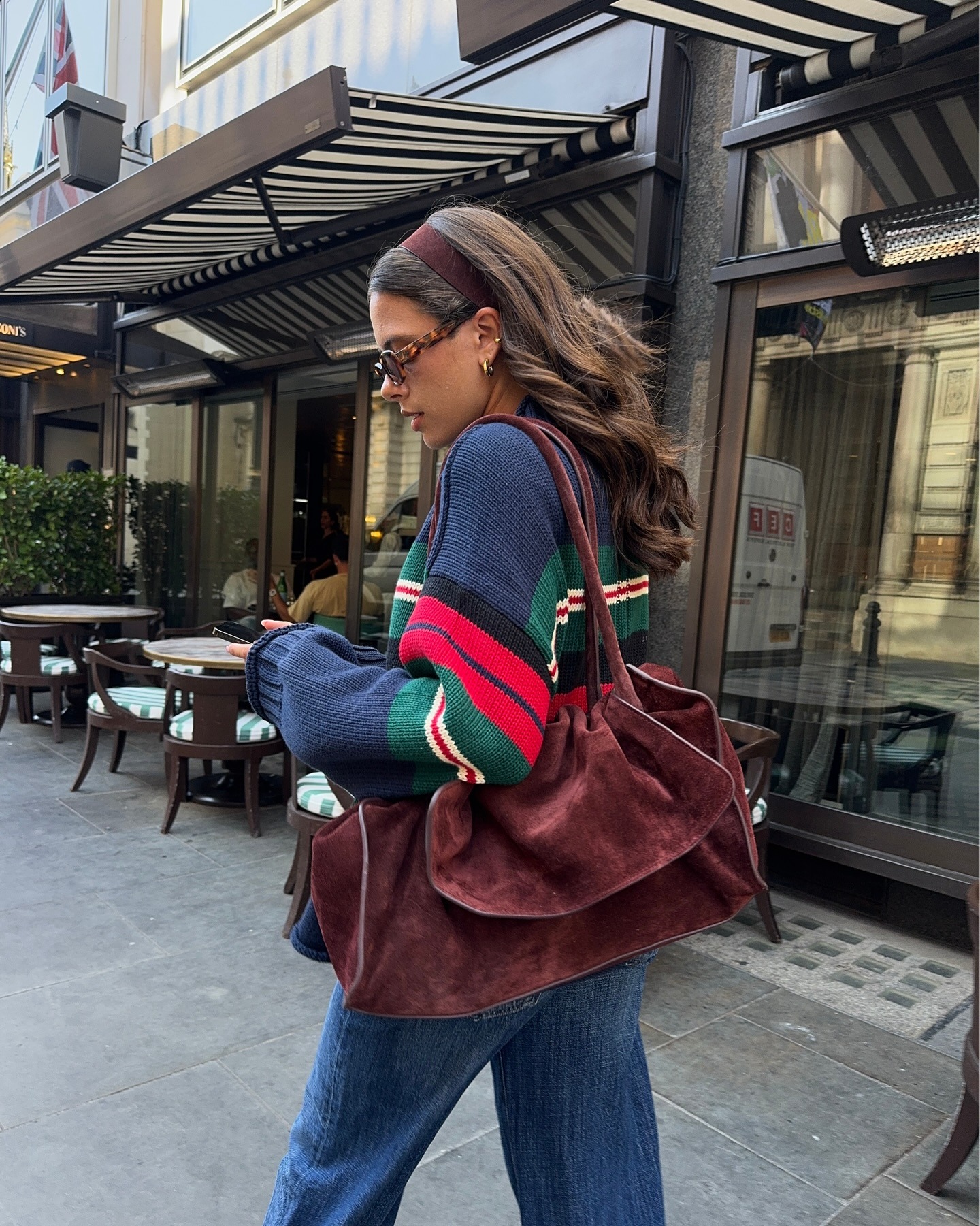 Fashion person Tia Dewitt wears alondon spring capsule wardrobe piece. She wears an oversized suede bag.