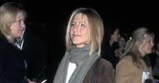 Jennifer Aniston wearing a suede coat, blue jeans, and snakeskin boots