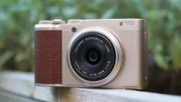 The Fujifilm XF10 perched on a wooden handrail outside