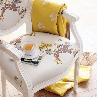 room with printed white chair and white cup with plate