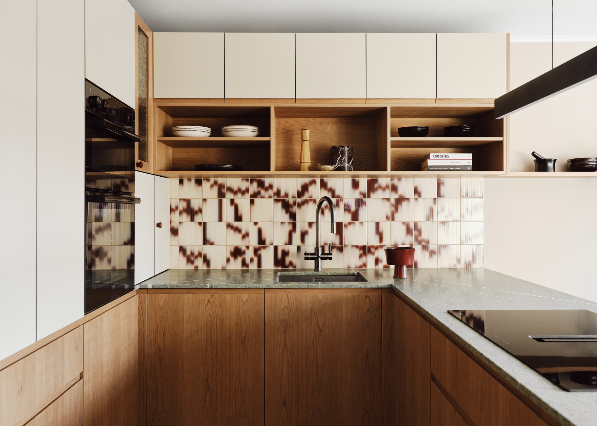 holte showroom kitchen with palet tiles backsplash, wooden cabinets, and green stone counters
