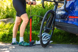 Image shows a rider using a bike pump.