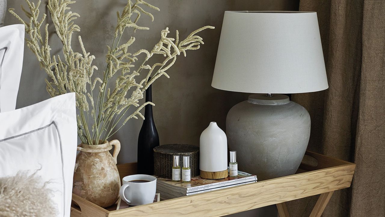 Southwold Table Lamp on bedside table next to electric diffuser, essential oils, and vase