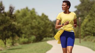 A woman wears the Fitbit Versa 3 running