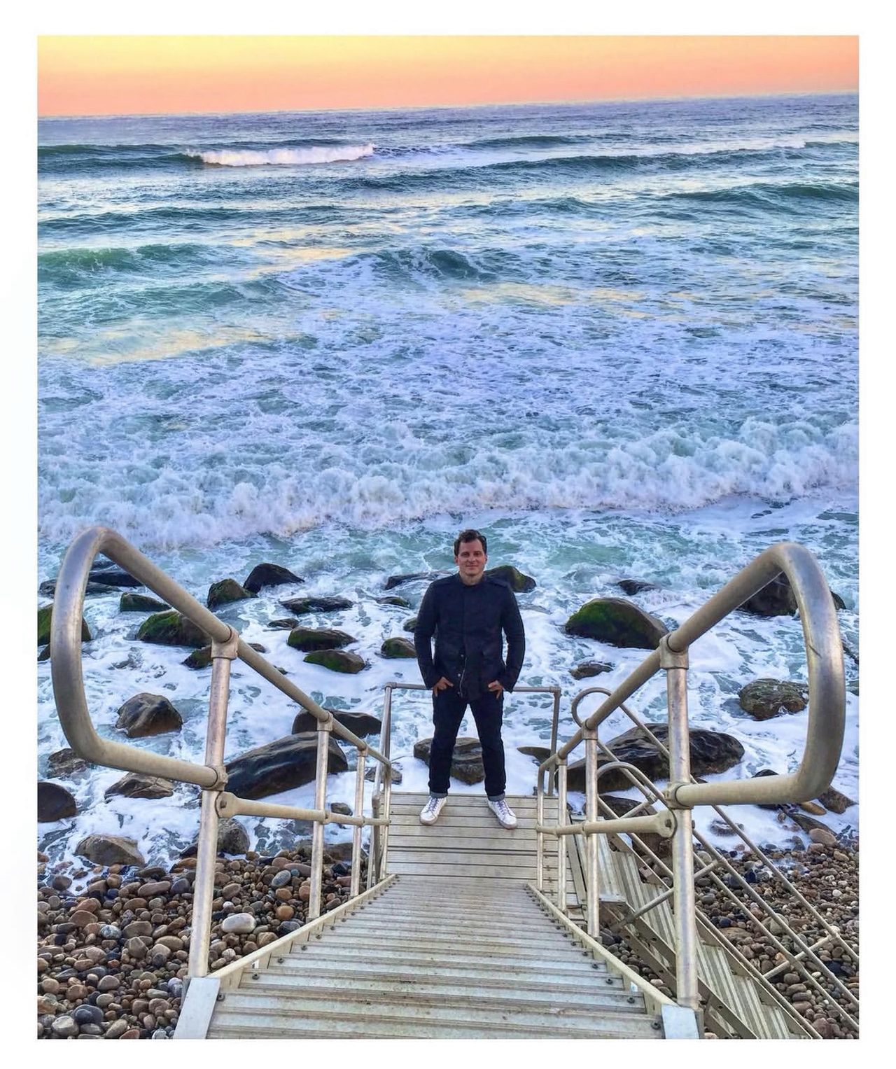 Man on stairs in front of beach