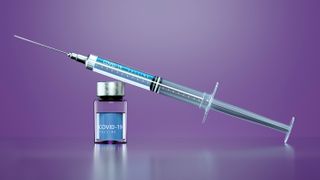 Image of a syringe and COVID-19 vaccine.