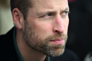 A closeup of Prince William wearing a dark blazer and looking thoughtful and serious