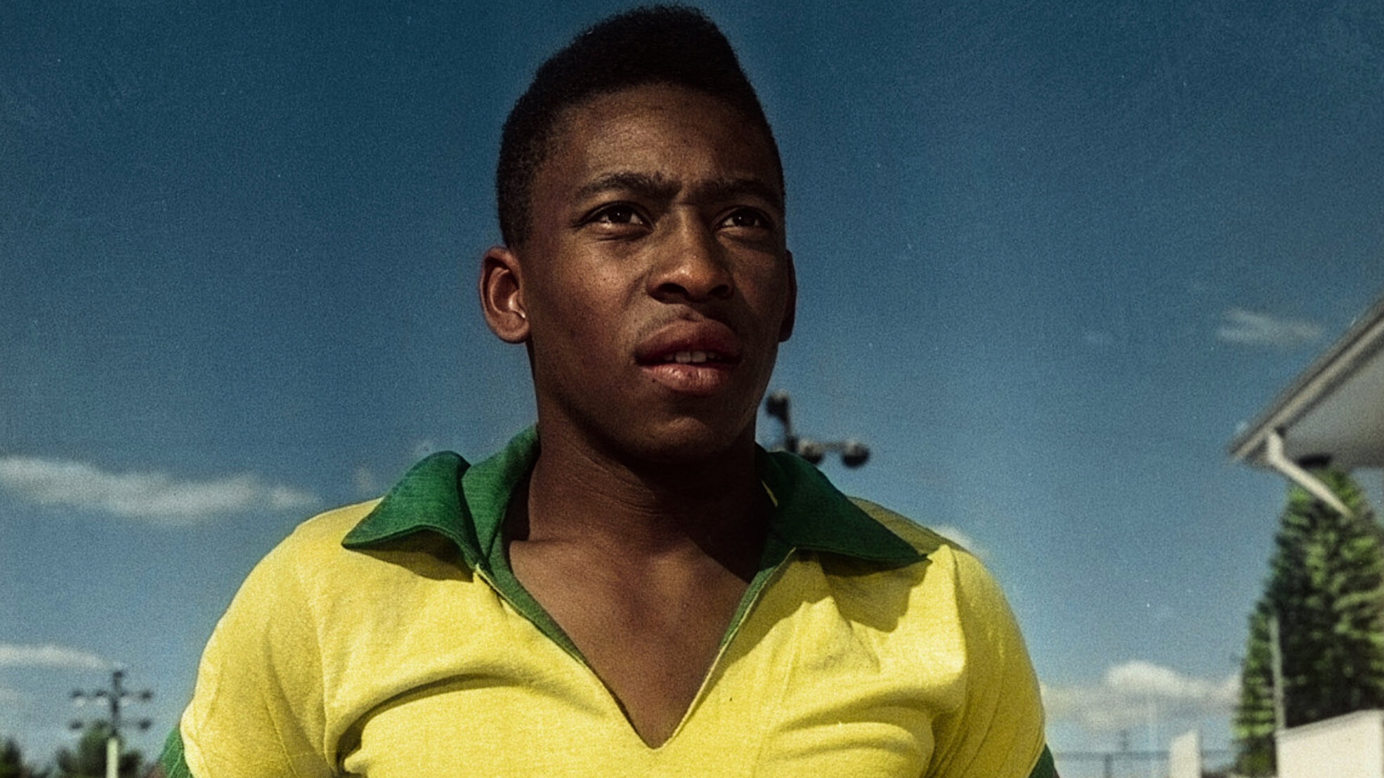 Brazil's Pele wearing yellow 1970s Brazil national soccer team jersey with blue sky background from the Netflix documentary 