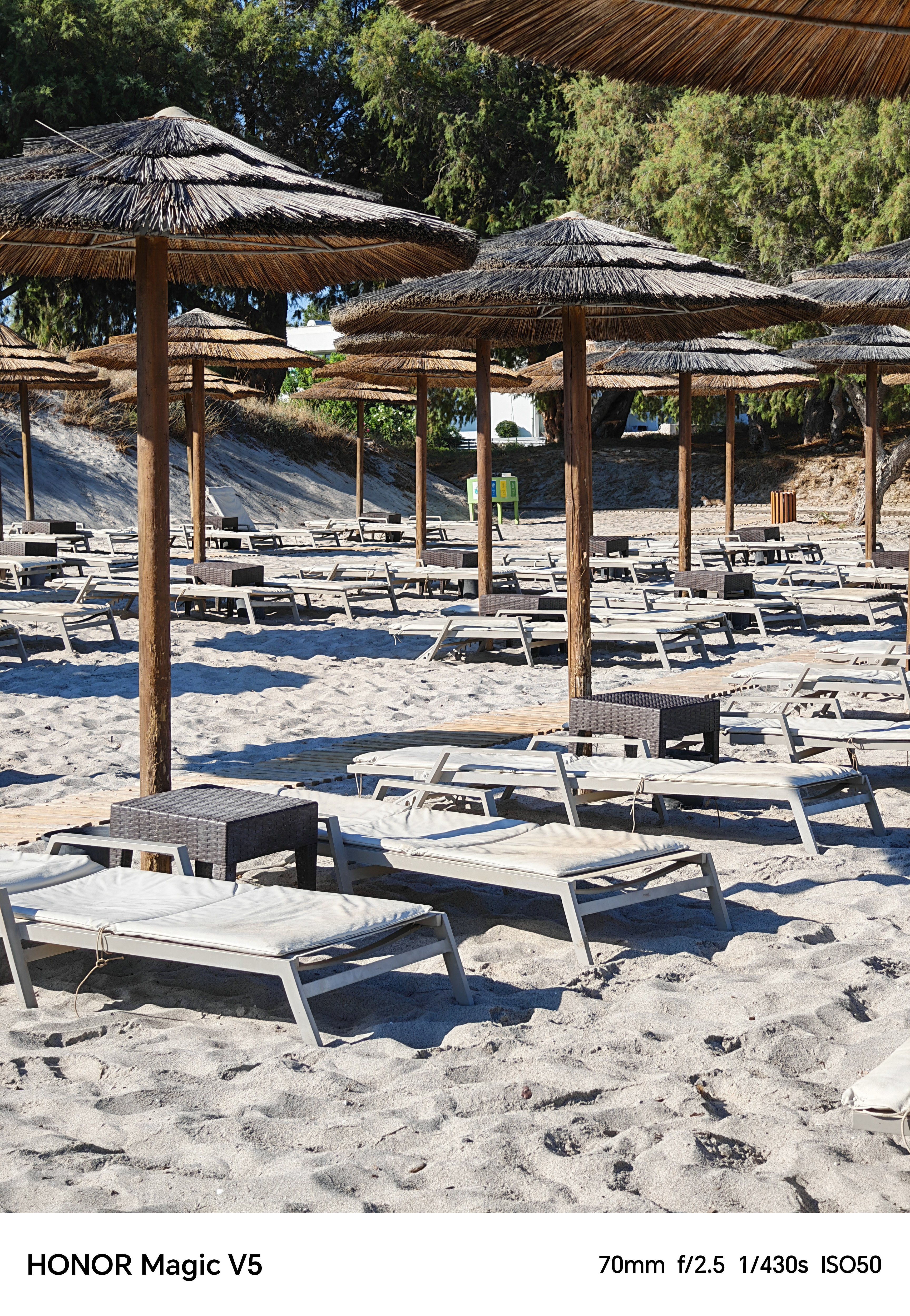 Empty deck chairs and parasols lined up on a beach