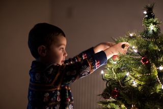 boy decorating Christmas tree