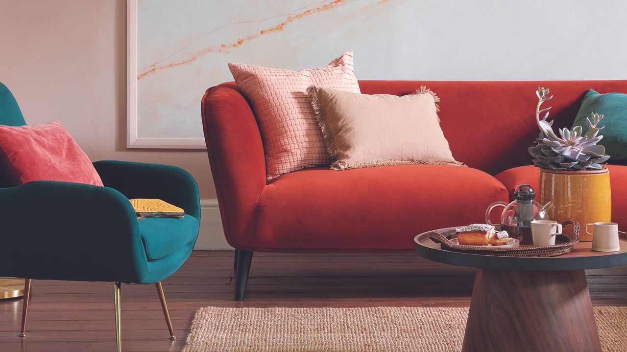 Living room with red sofa, standing lamp and coffee table.