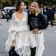 Two guests at the Chloé show in Paris, wearing head-to-toe looks and Chloé perfume