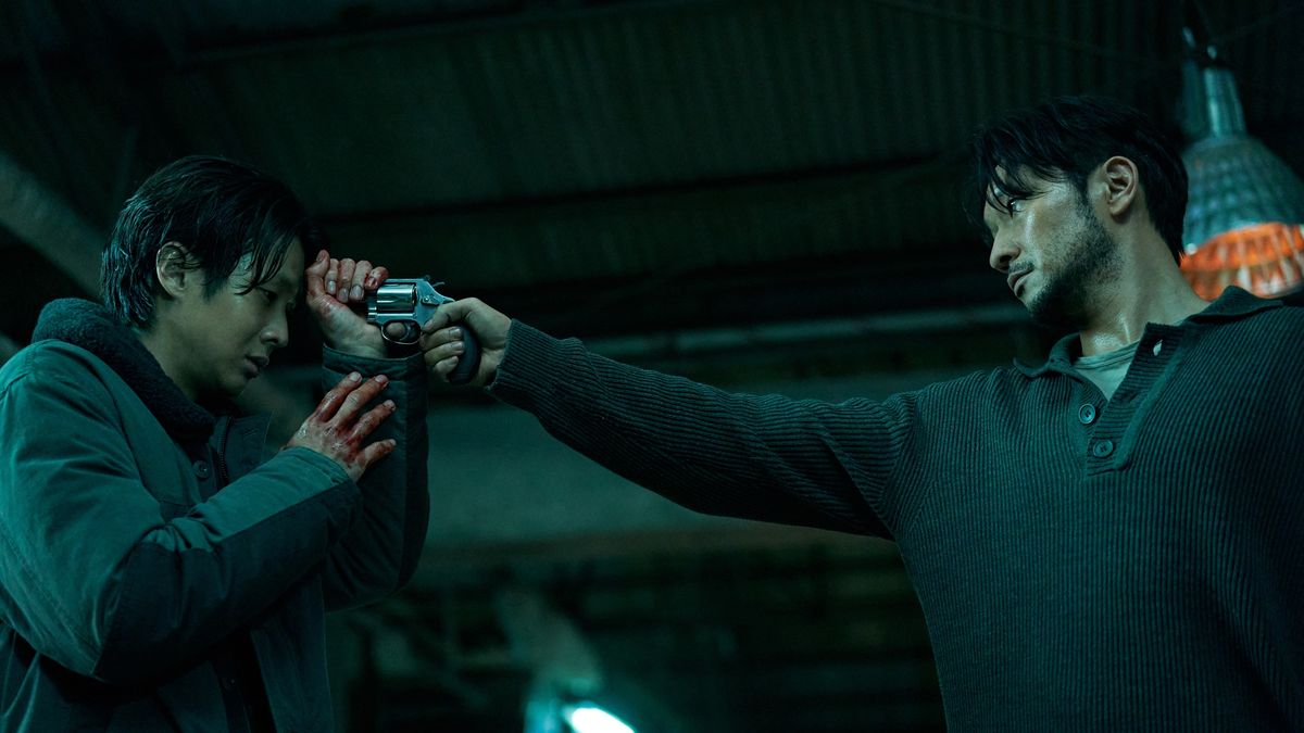 Jang Nan-gam (Son Suk-ku) with a gun to Lee Tang&#039;s (Choi Woo-shik) head in Netflix&#039;s A Killer Paradox.