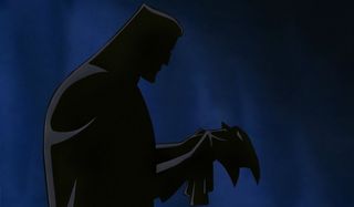 Batman: Mask of the Phantasm Bruce holds his mask in the dark