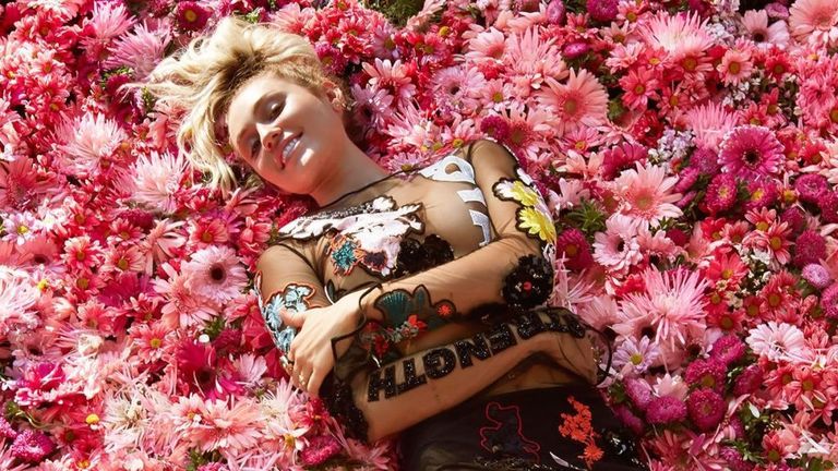 Miley Cyrus lying on heart-shaped roses