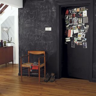 chalkboard wall with wooden flooring and rush chair