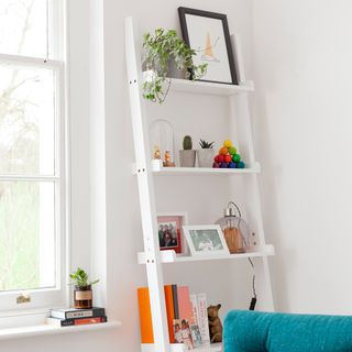 white wall living room with ladder shelving and white window