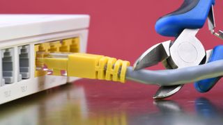 Someone cutting a network cable linked to a router