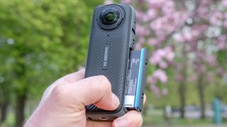 A photo of the Insta360 X4 with the battery part slid out of its compartment.