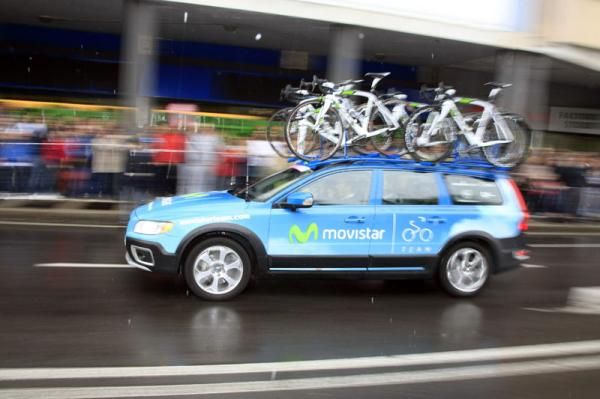 Movistar's team car drive off to get positioned for the start