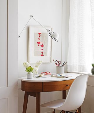 An example of decorating small spaces by fitting a desk into a nook in a white living room scheme.