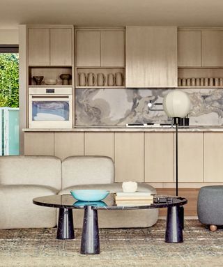 a neutral open concept kitchen living room with a black coffee table