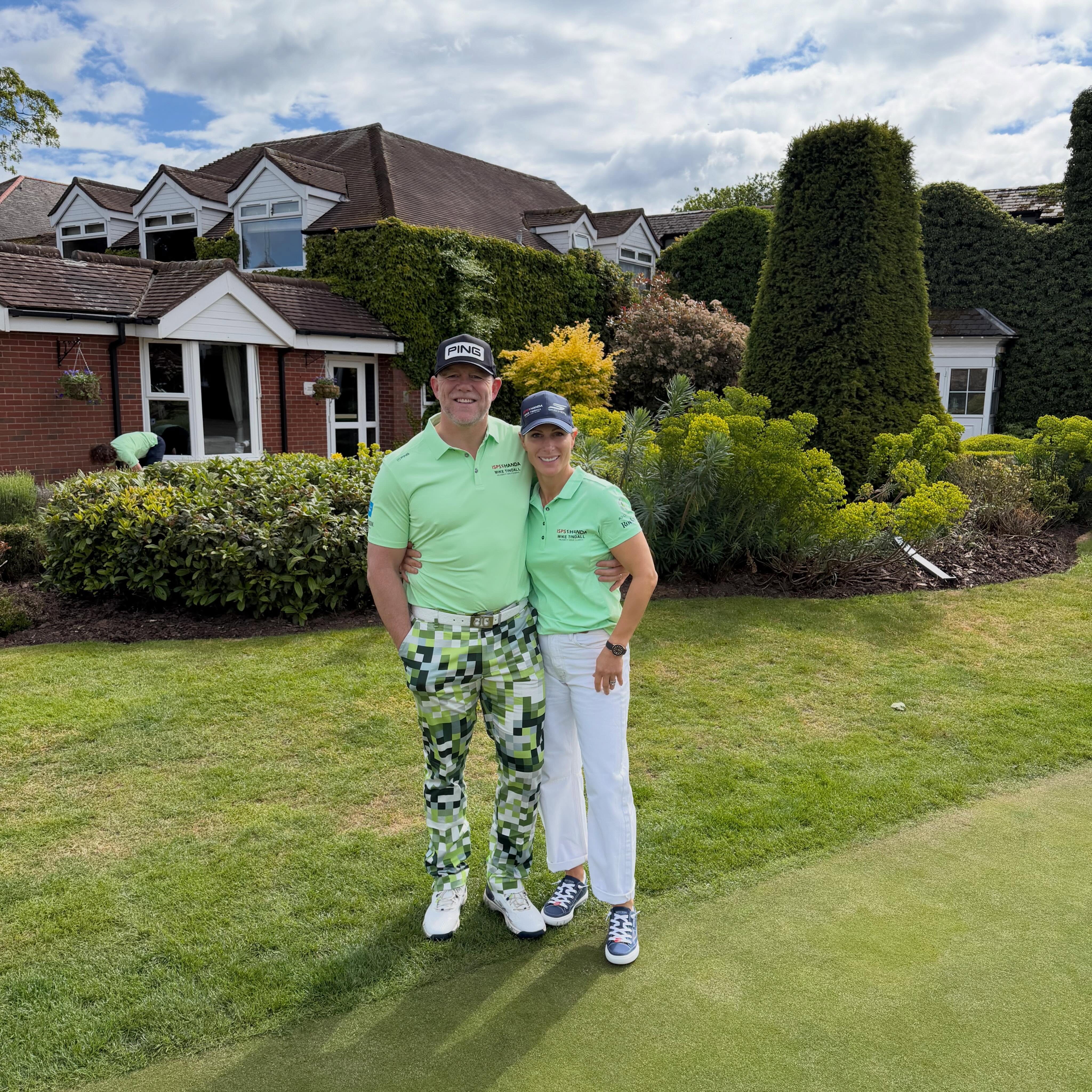 Mike and Zara Tindall wearing green polo shirts in front of a hotel