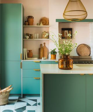 Teal kitchen cabinets with black and white geometric flooring and striking pendant lights