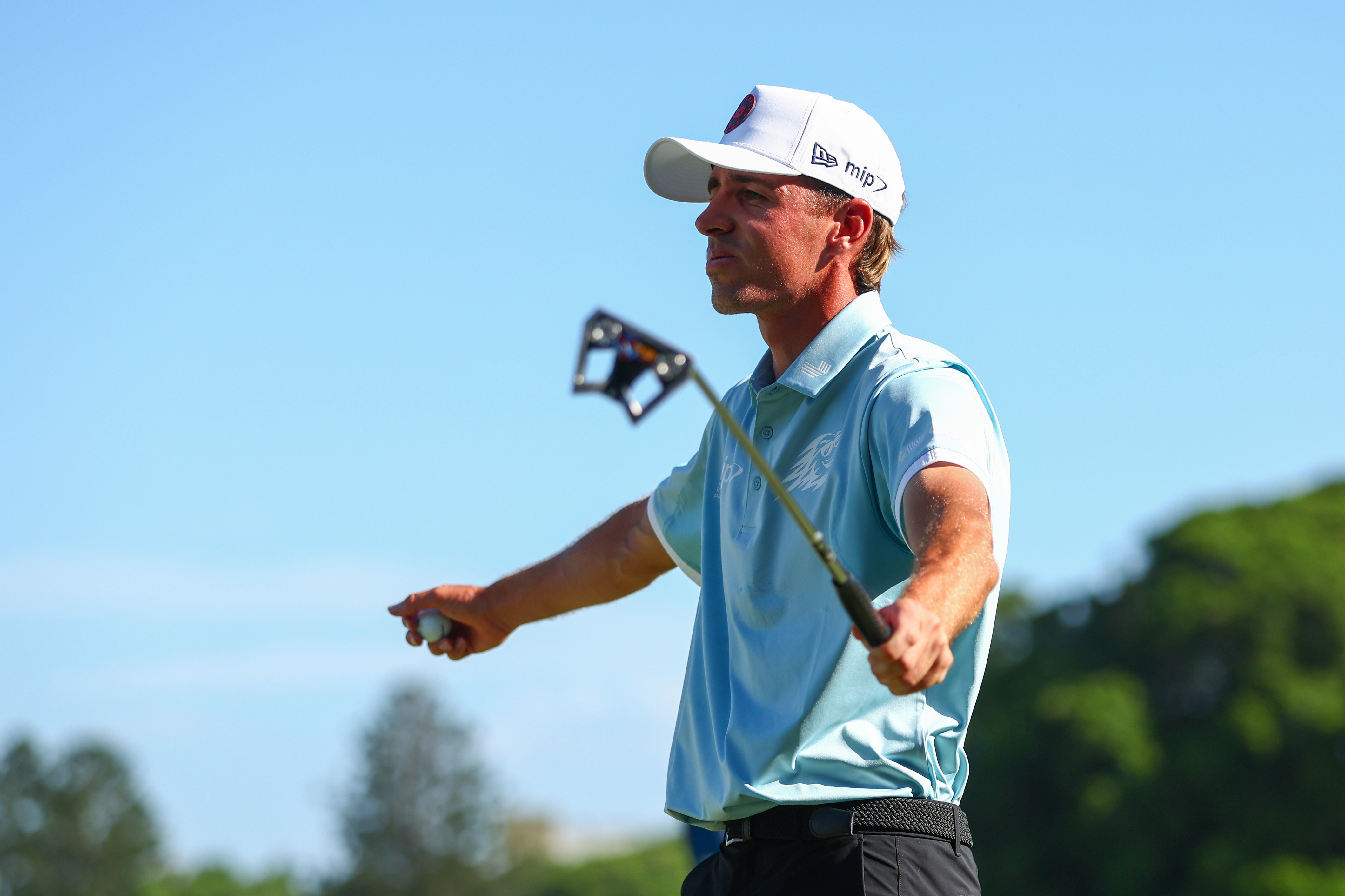 David Puig raises his putter in the air