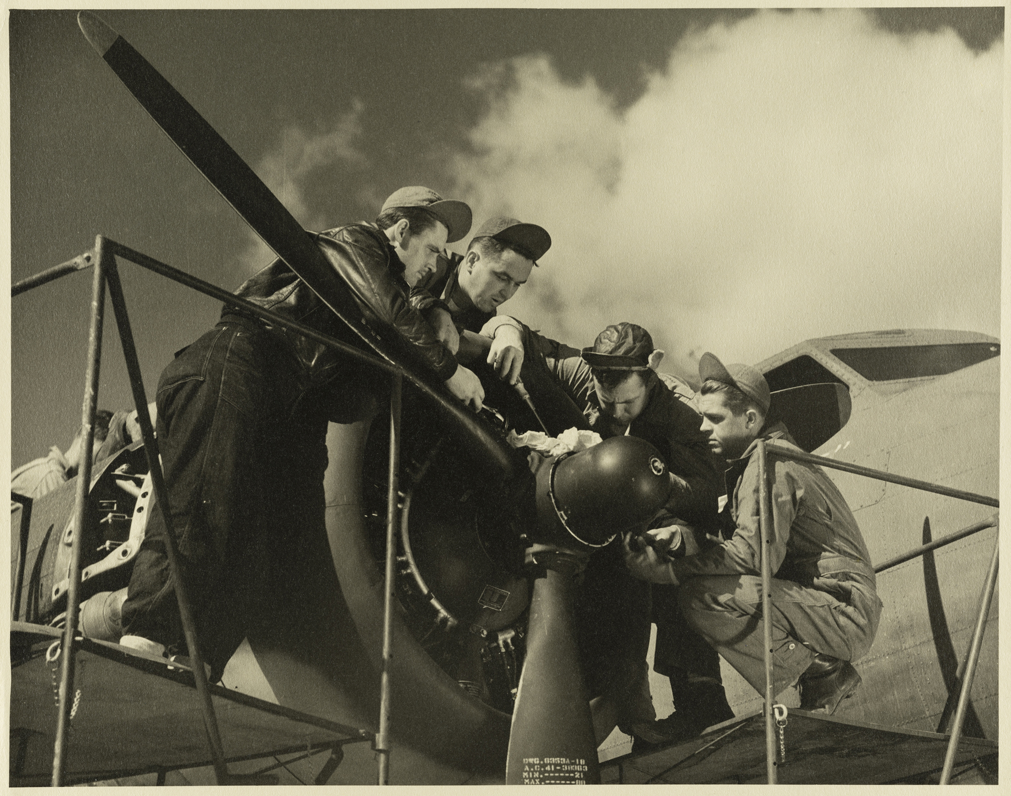Still from a film produced by the RAF Film Production Unit during the Second World War, showing airmen around the propeller of an aircraft