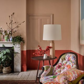 living room colour schemes, coral and red living room with floral sofa, vintage rug, flowers and plants, side table, large lamp