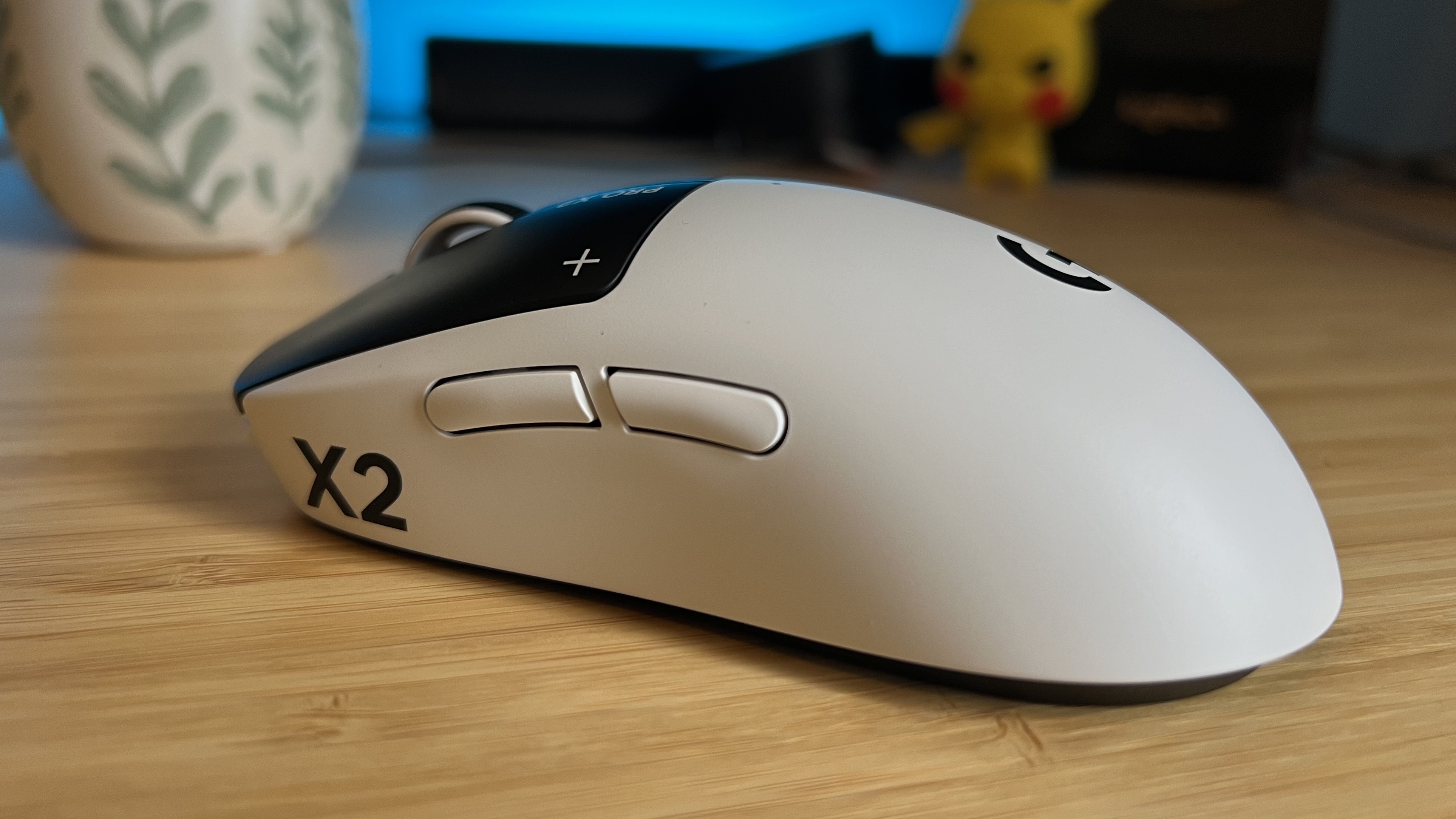 Side view of Logitech G Pro X2 Superstrike gaming mouse on a wooden desk