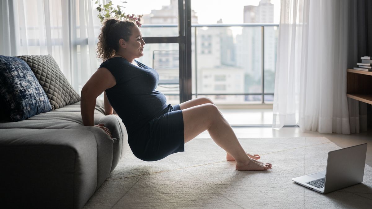 Woman uses couch to perform triceps dips at home