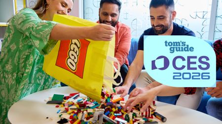 A person pouring a bag of Lego bricks onto a table while three others shuffle through the pieces with a Tom's Guide CES 2026 logo overlaid.
