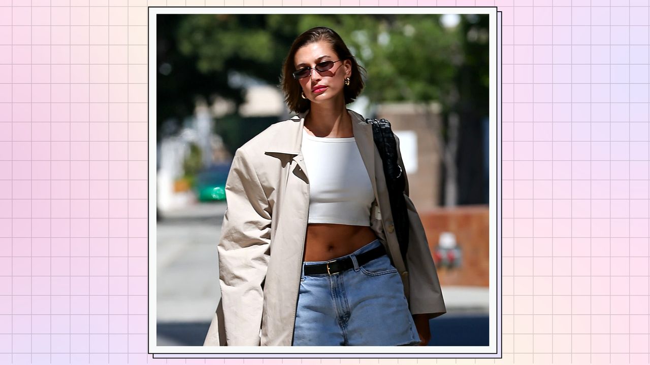 Hailey Bieber is pictured wearing sunglasses, a trench coat and denim shorts on June 27, 2023 in Los Angeles, California/ in a pink,cream and purple template