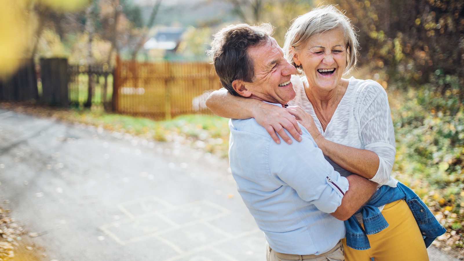 Old man and woman in love spending time outdoors, laughing.