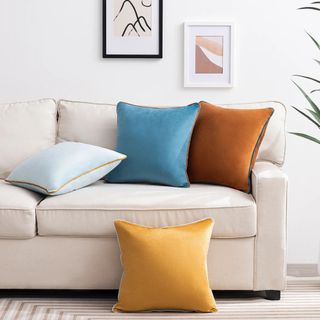 Four velvet pillows from Walmart on a white couch