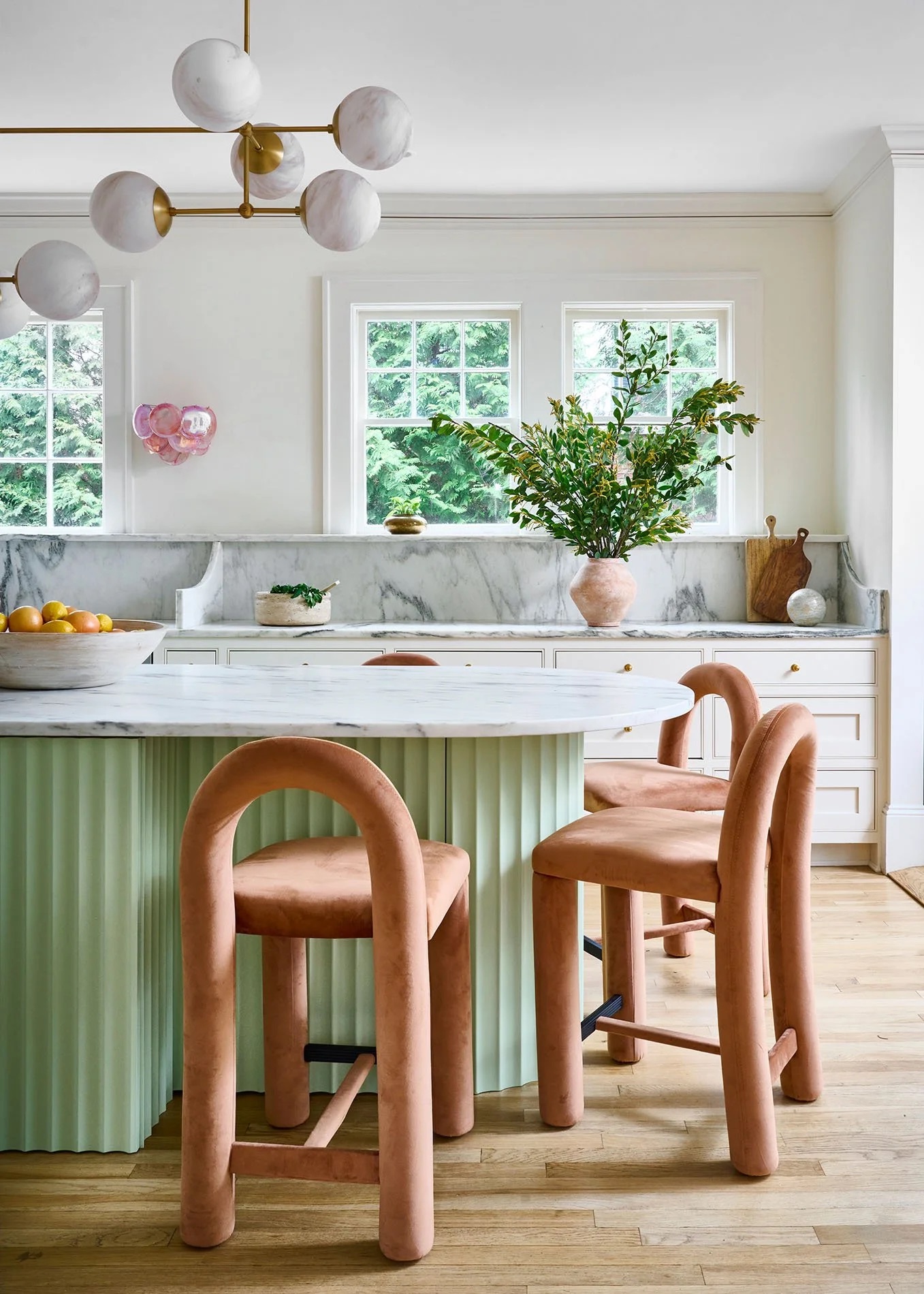 A kitchen with chubby tubular bar stools in pink velvet