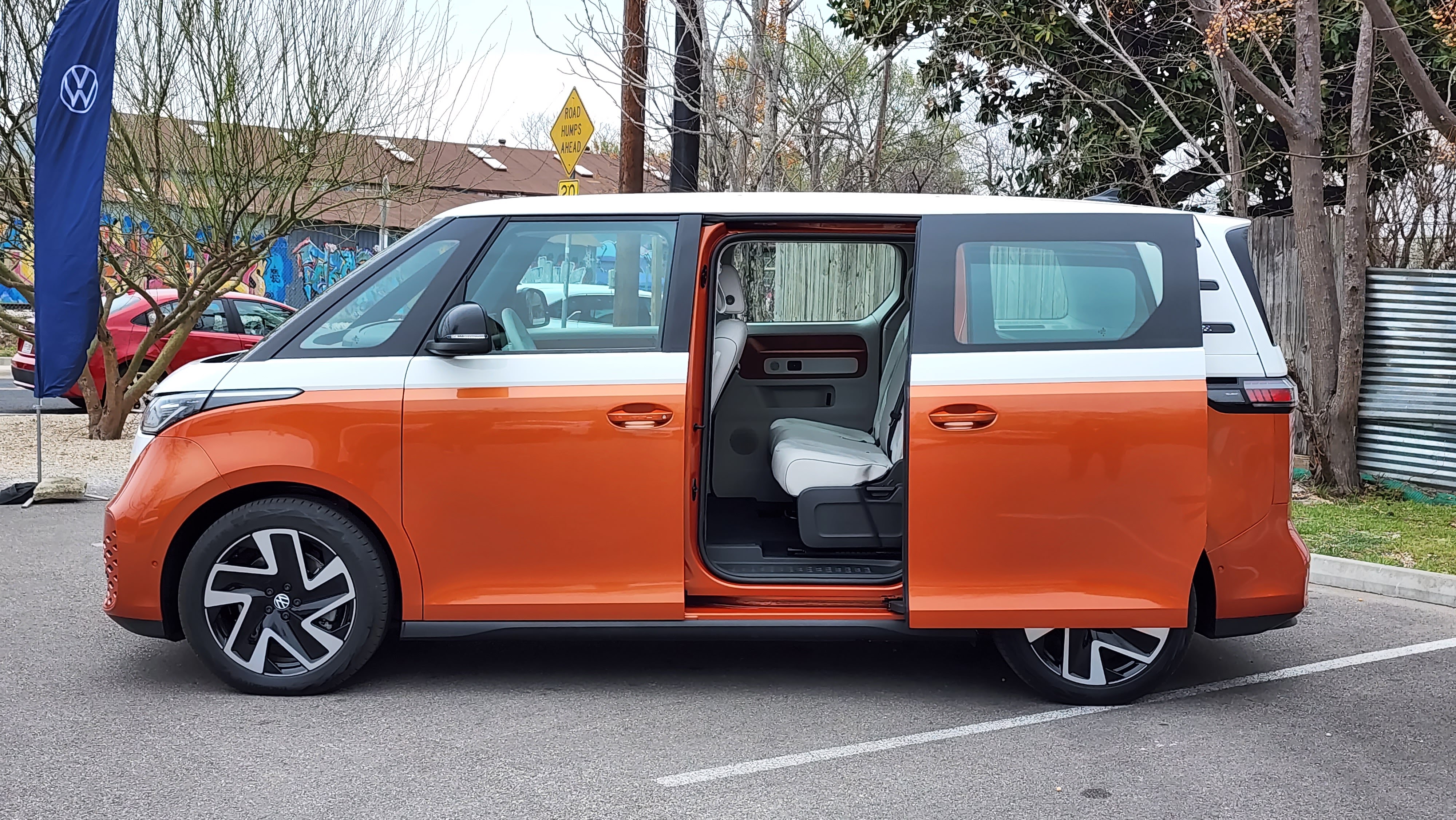 Side view of the ID Buzz with sliding door open, in a parking lot